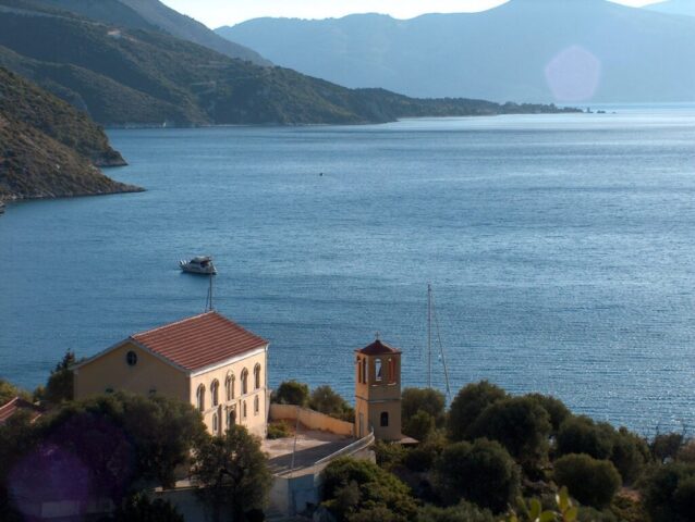 Veduta di Porto Leone sull’isola di Kalamos, con la bella chiesa ortodossa ancora funzionante e le poche case abbandonate affacciate sul mare.